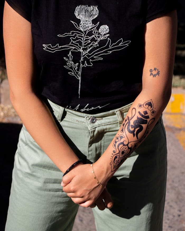 Young woman poses with intricate floral tattoos, merging fashion and art.